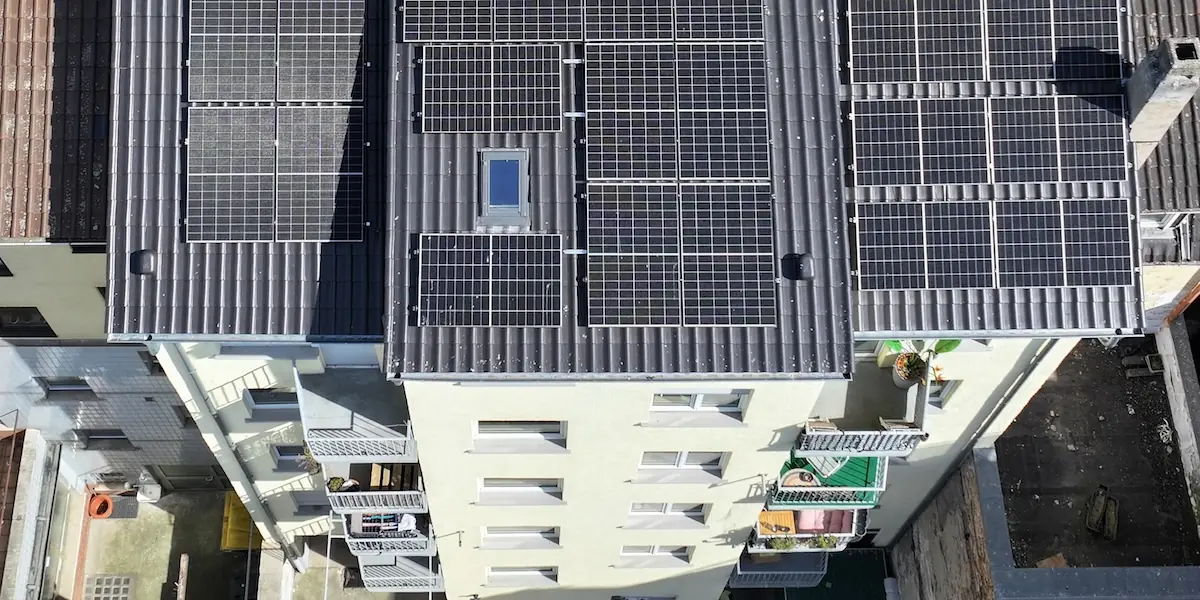 Luftbild eines Altbaus mit Solaranlage auf dem Dach und Balkonen zum Hof